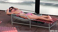 Hot brunette sunbathes and takes a dip in the spa, then goes in