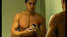 Muscular stud jerks his massive dick while looking at himself in the mirror